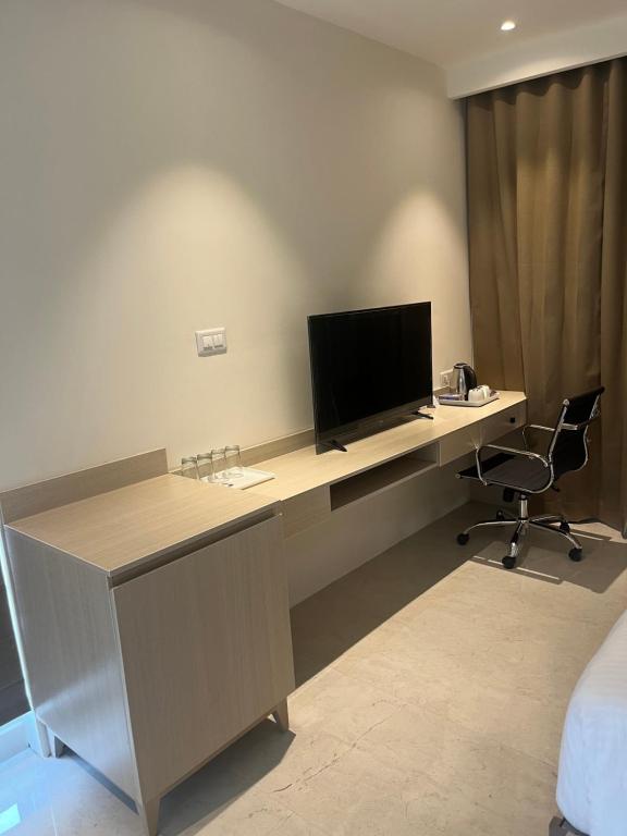 an office with a desk with a television on it at PRESIDENCY AIRPORT HOTEL in Cochin