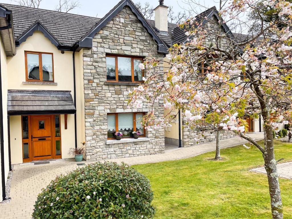 una casa con un albero da fiore di fronte di Lough Rynn Rental a Mohill