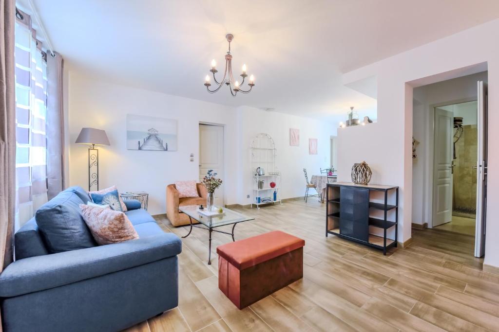 sala de estar con sofá azul y mesa en Les Gîtes de Nathalie: Corneille et Rivals en Carcassonne