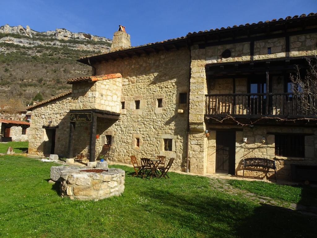 - un grand bâtiment en pierre avec une terrasse couverte et un balcon dans l'établissement LA CASONA DE ESCALADA, à Escalada