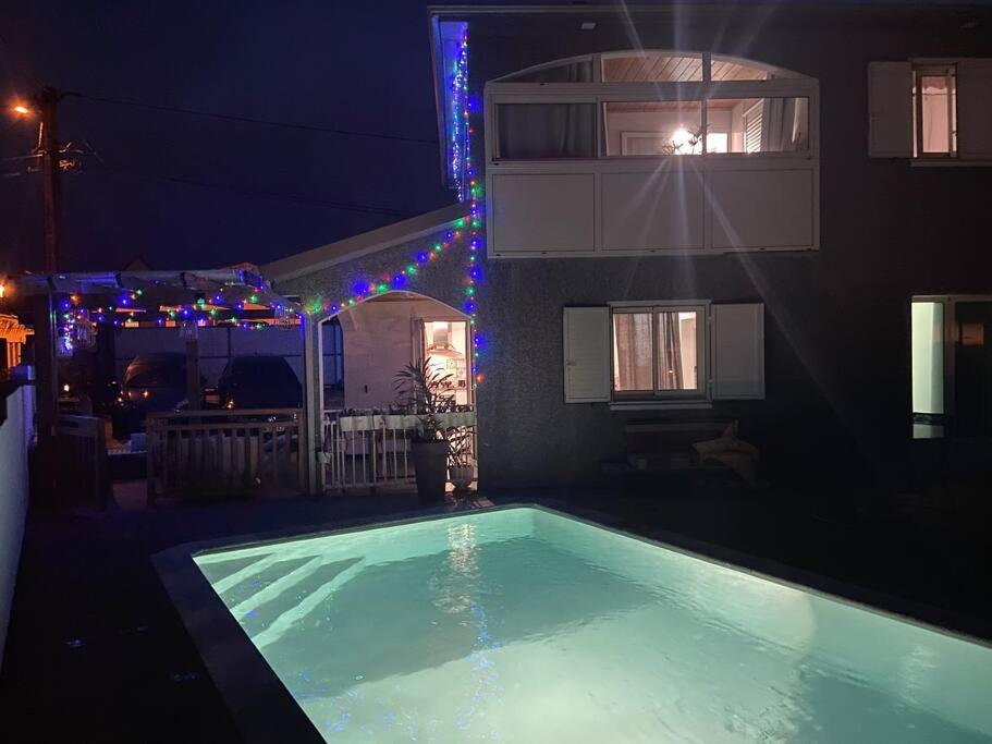 a swimming pool in front of a building at night at Villa Bois Court 3 chambres in Le Tampon