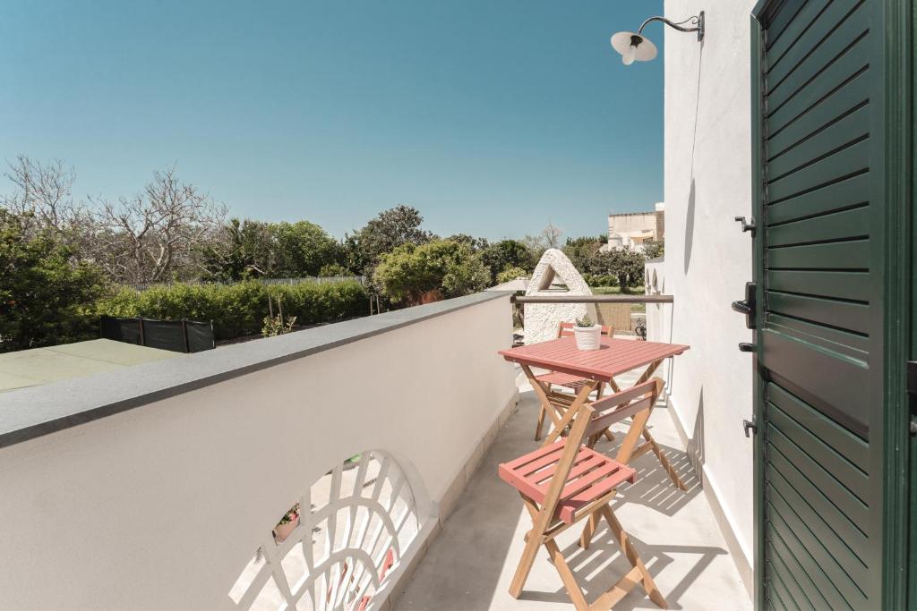 a small table on the balcony of a house at Cala Cala Rooms,Restaurant & Farm Experience in Procida