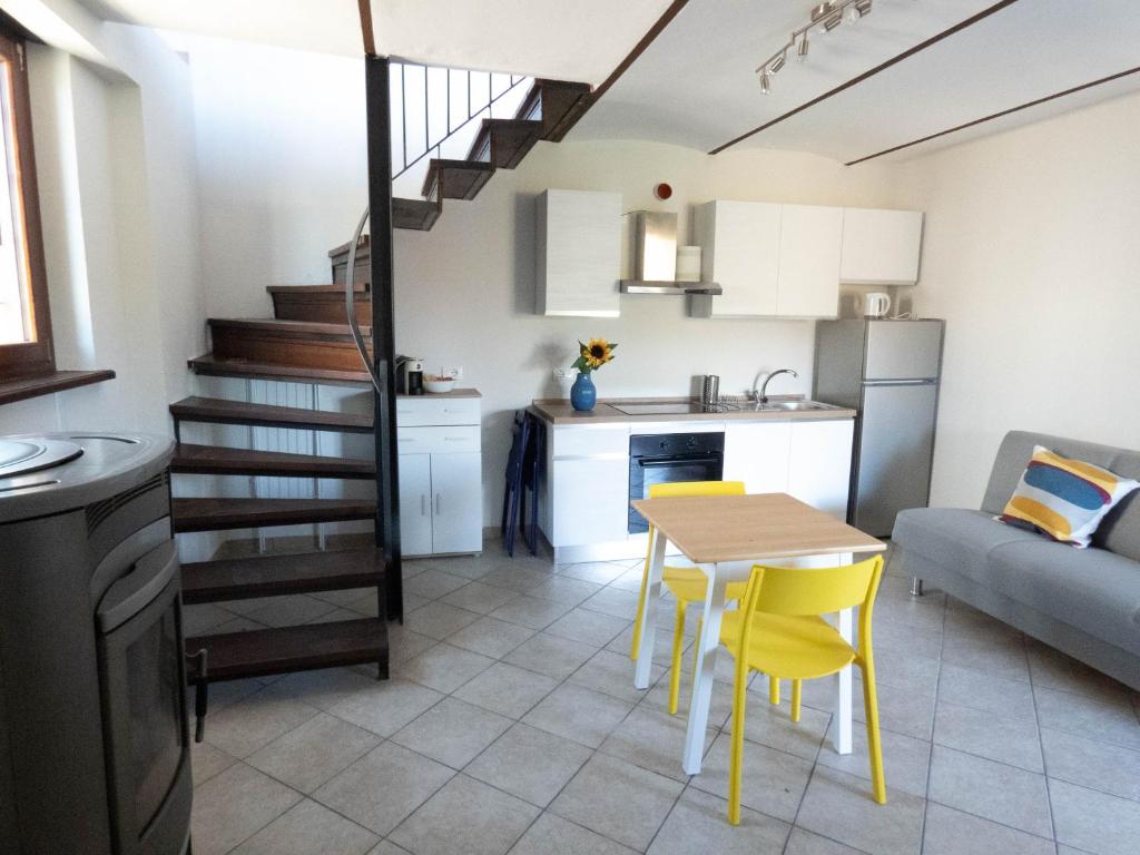 een keuken en een woonkamer met een tafel en gele stoelen bij Casa Lucrezia in Alba