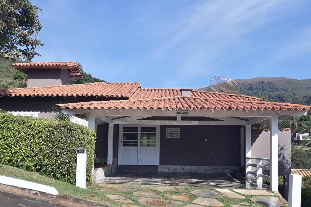 une maison avec un garage à toit rouge dans l'établissement Casa Escarpas do lago, à Capitólio