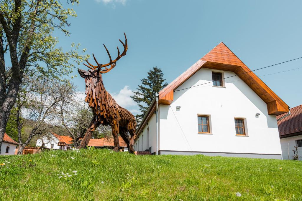 a statue of a giraffe standing on a hill next to a building at GLASHÜTTE Kisújbánya Vadászház in Hosszúhétény