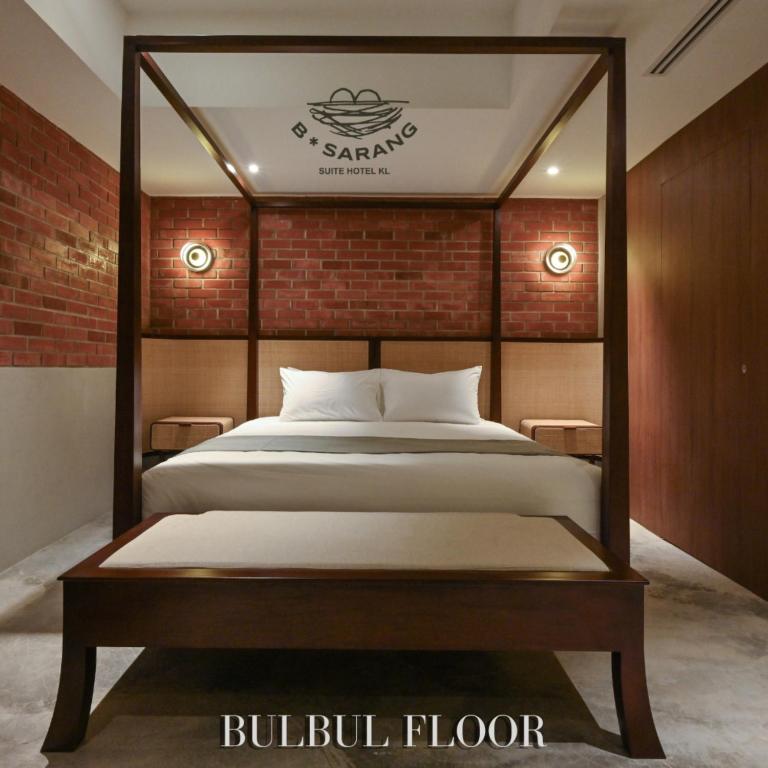 1 dormitorio con cama y pared de ladrillo en B Sarang Suite Hotel Kuala Lumpur, en Kuala Lumpur