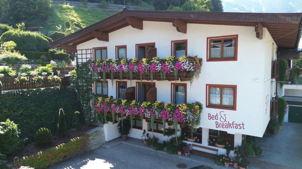 un bâtiment avec des fleurs sur son côté dans l'établissement Zimmervermietung Babsy, à Zell am See