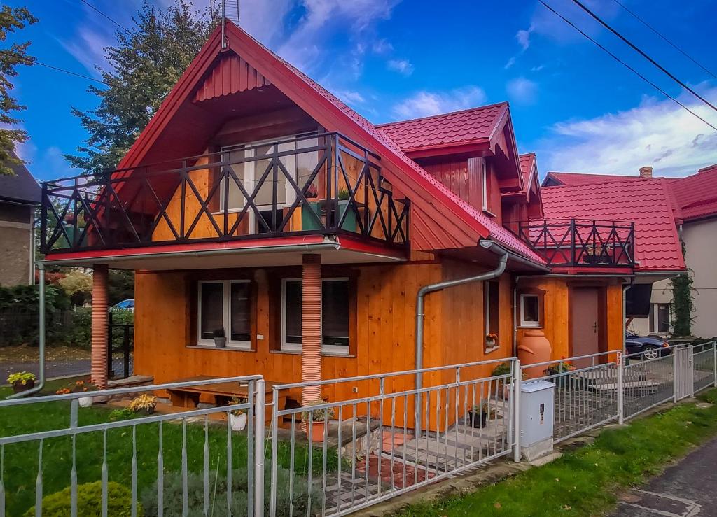 uma casa com um telhado vermelho em Koniczynka em Ściegny