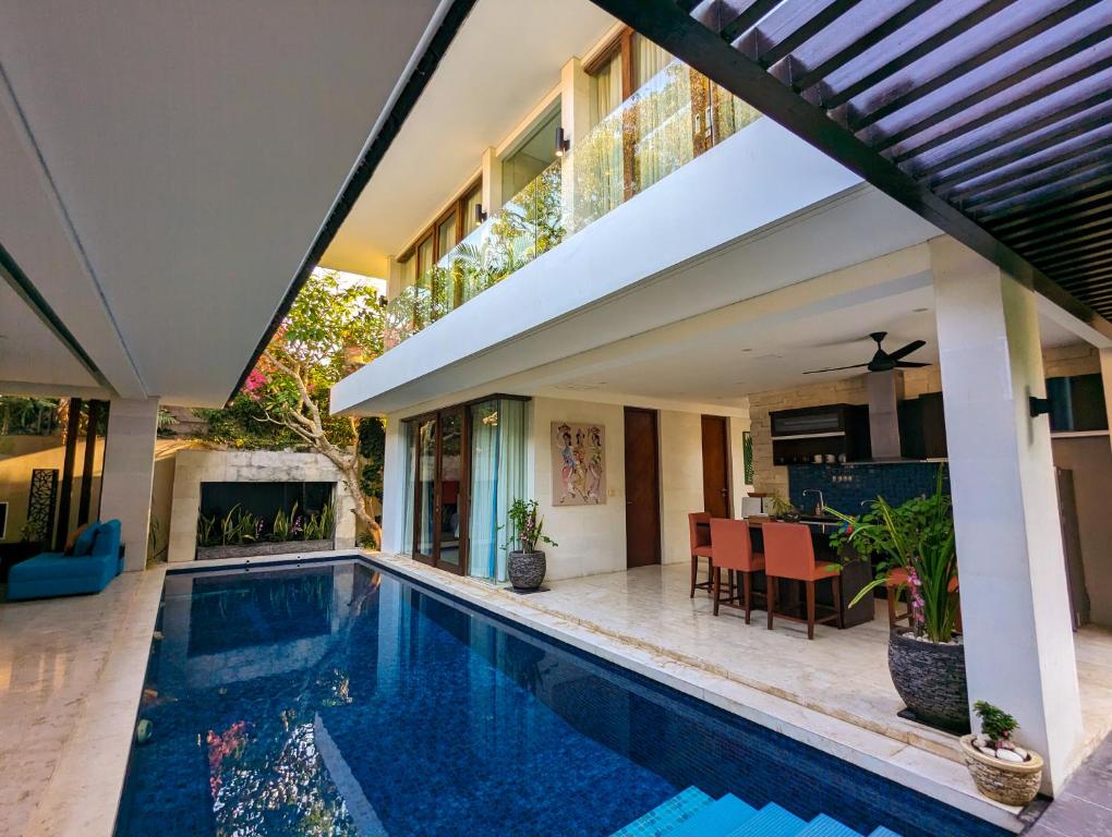 a house with a swimming pool next to a house at Indi Villas - The Bhadra Villa in Seminyak