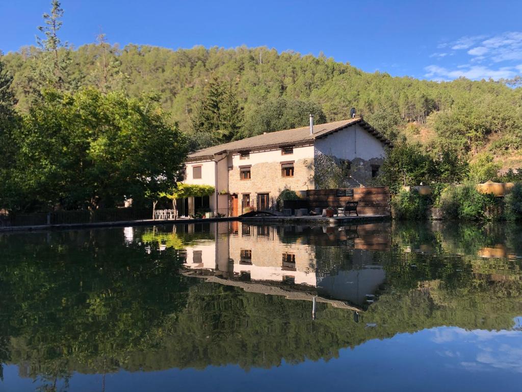 una casa en el agua con su reflejo en Casa dels Peixos, en La Baronia de Rialb