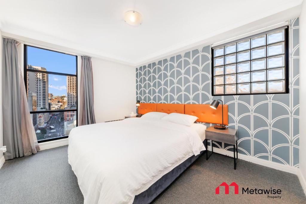 a bedroom with a large bed and two windows at MetaWise Sydney CBD Haymarket 2Bed Apartment 1506 in Sydney