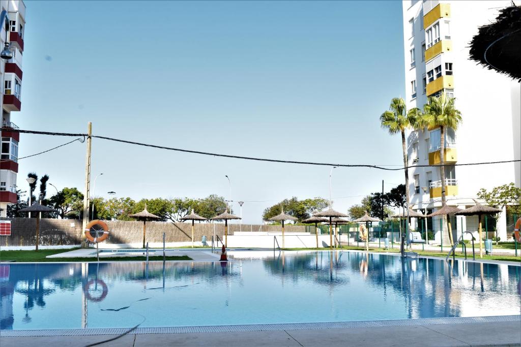 a large swimming pool in the middle of a city at Apartamento Puertomar in El Puerto de Santa María