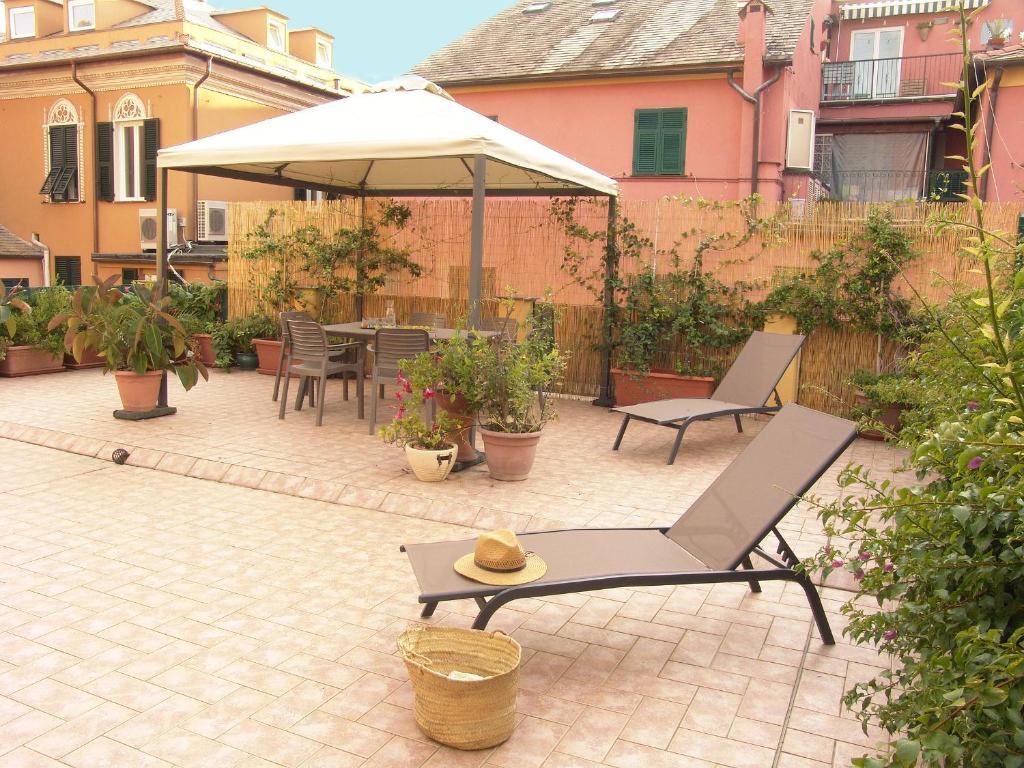 un patio con tavolo, ombrellone e sedie di Residenza Cavour - Appartamento AGAVE a Levanto