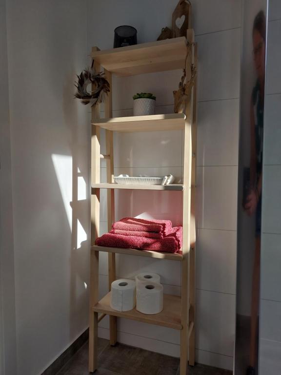 uma prateleira numa casa de banho com toalhas em Ferienwohnung Witten Gederbach em Witten