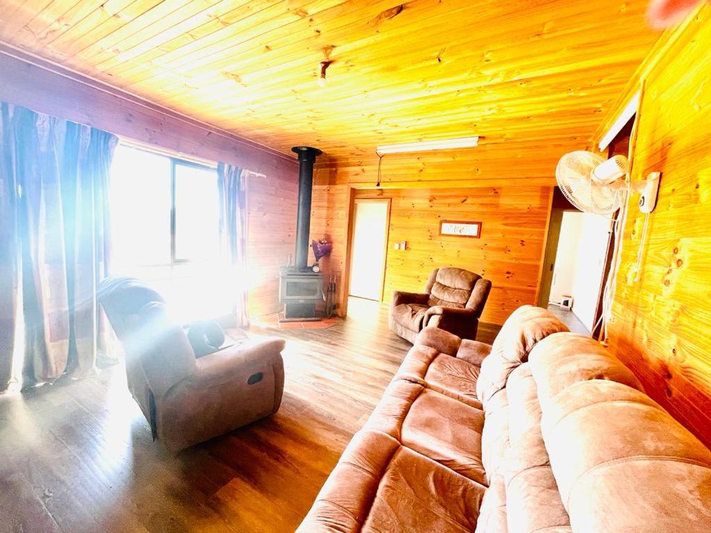 a living room with a couch and a chair at Ross Creek farm Stay 