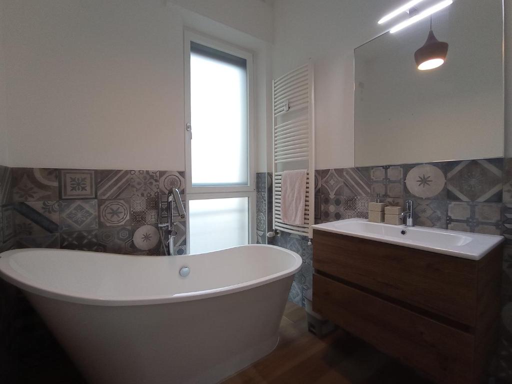 uma casa de banho com uma grande banheira branca e um lavatório. em Terrazza18 em Milão