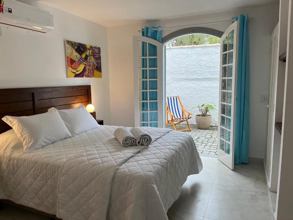 um quarto com uma cama e uma porta aberta para um pátio em Casa Arte Cabore em Paraty
