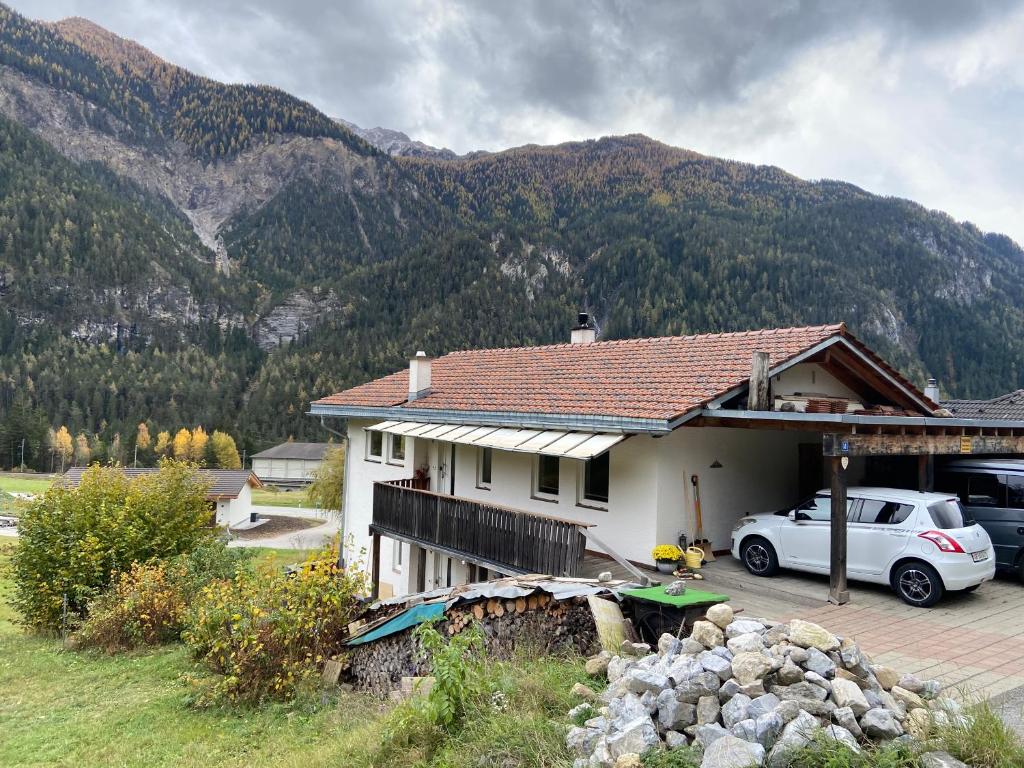 un coche blanco estacionado frente a una casa en Ferienwohnung im Herzen Graubündens, en Surava