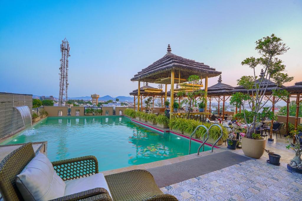 a large swimming pool with a gazebo at The Belmonte House By Levelup in Udaipur