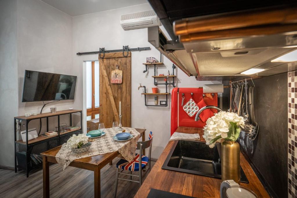 una cucina e un soggiorno con un tavolo e una TV di Civico 65 ad Arezzo