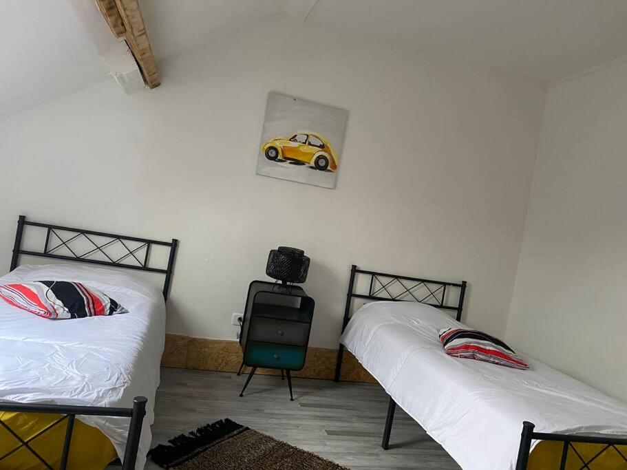 - une chambre avec 2 lits et une voiture jouets sur le mur dans l'établissement Maison cosy, terrasse & jardin, à Imphy