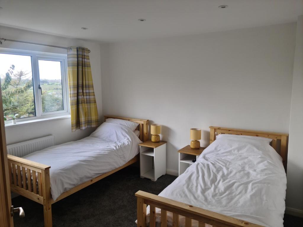 two twin beds in a room with a window at Minster Leas in Sheerness