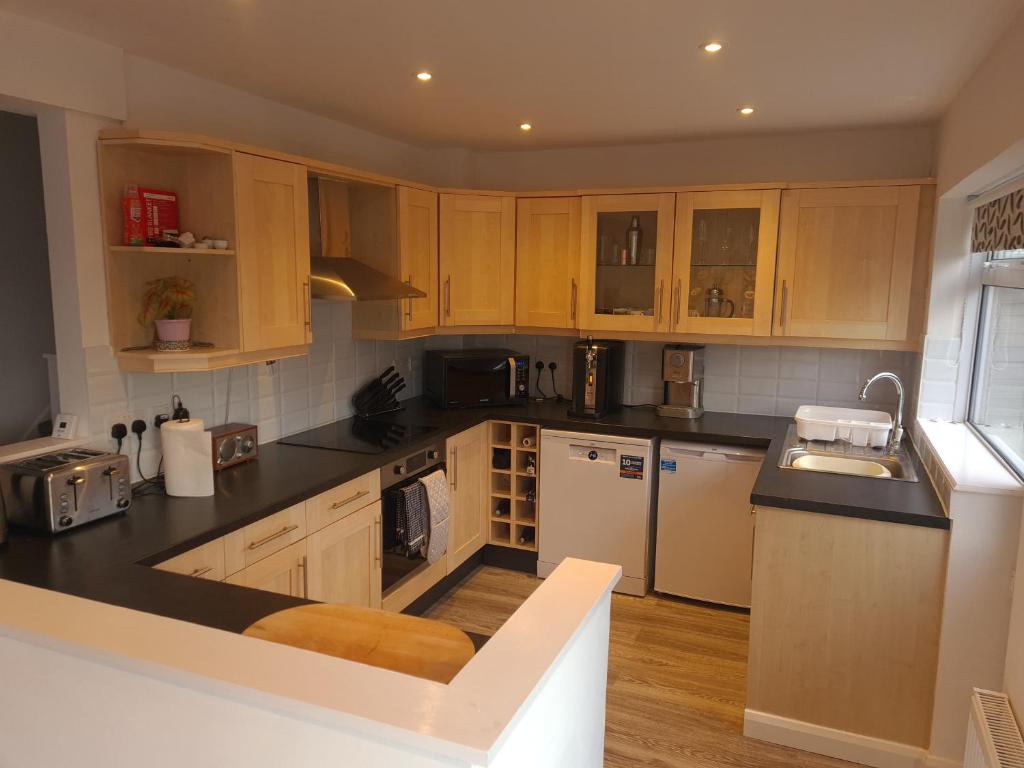 a kitchen with wooden cabinets and white appliances at Minster Leas in Sheerness