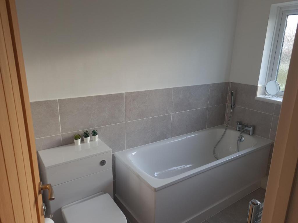 a bathroom with a tub and a toilet and a sink at Minster Leas in Sheerness
