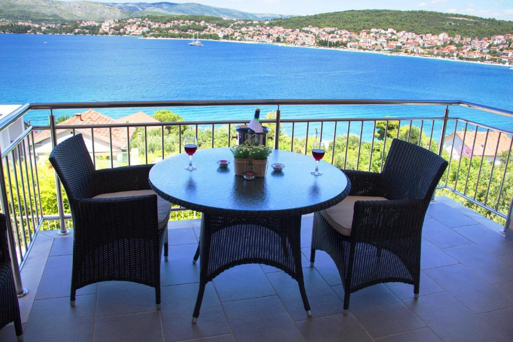 una mesa con 2 copas de vino en el balcón en Apartments Kelić, en Trogir