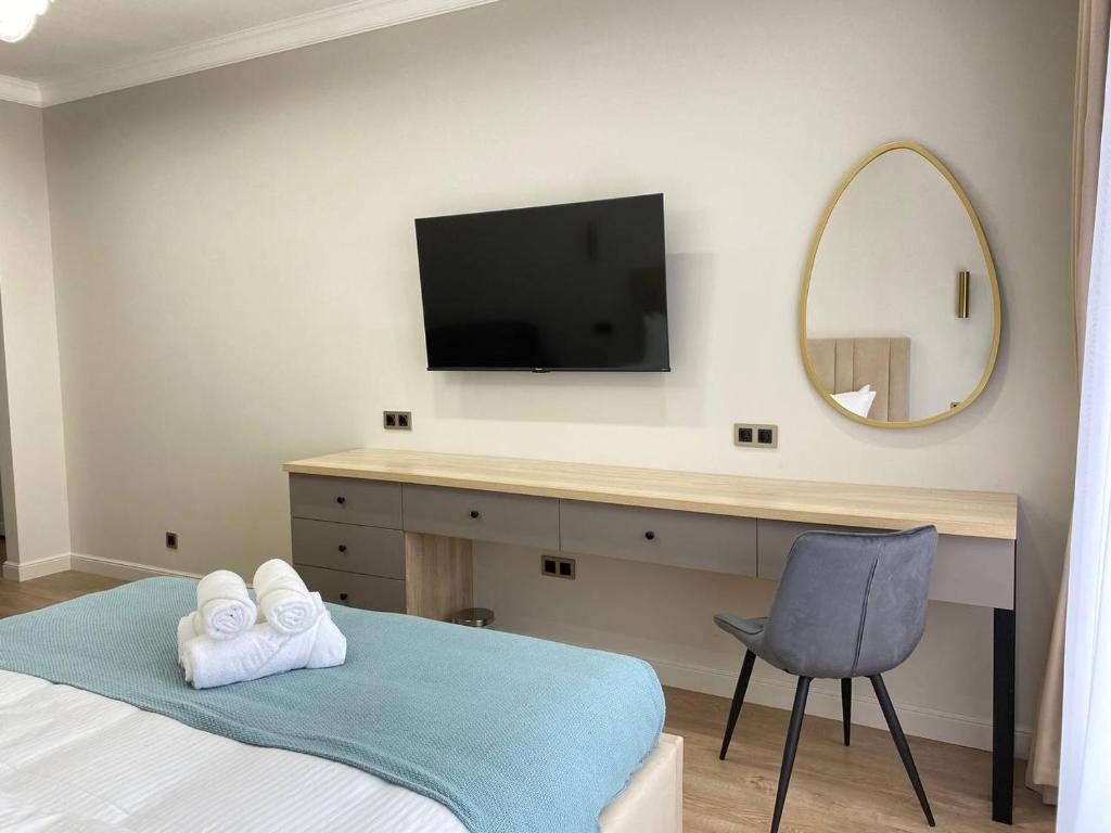- une chambre avec un lit et un bureau avec une télévision dans l'établissement Batysmura Бизнес, à Atyraū