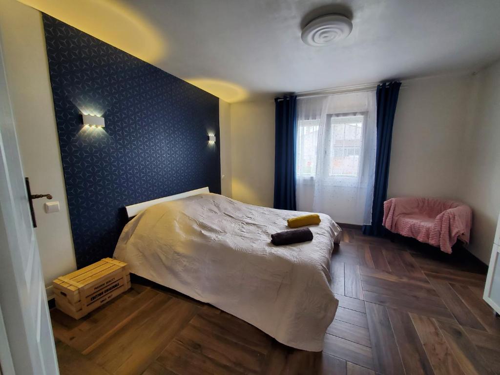1 dormitorio con cama y pared azul en Appart 28m2 avec jardin et parking privés, chambre séparée, en Milhaud
