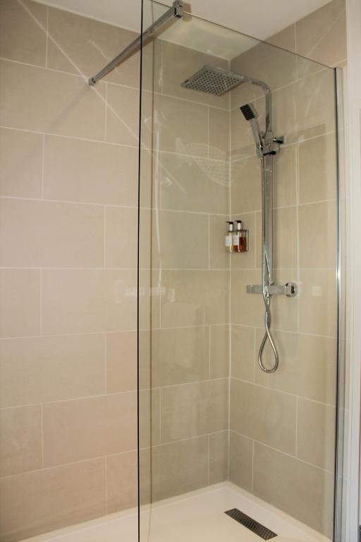 a shower with a glass door in a bathroom at The Ship Inn in Rye