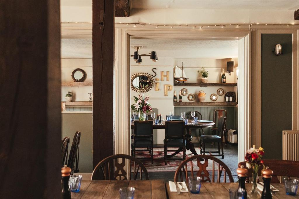 a dining room with a table and chairs and a room with a kitchen at The Ship Inn in Rye