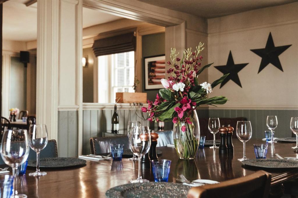a table with a vase of flowers and stars on the wall at The Ship Inn in Rye