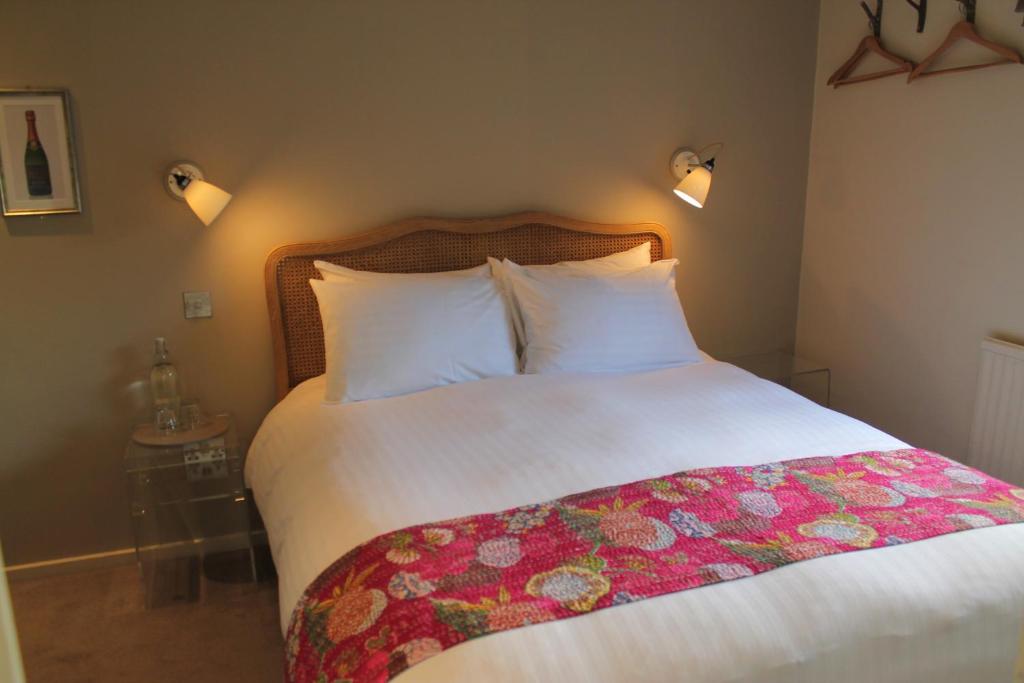 a bedroom with a large bed with a flower blanket on it at The Ship Inn in Rye