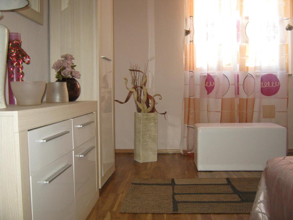 a room with a white cabinet and a vase with flowers at Guesthouse Linna in Vodice