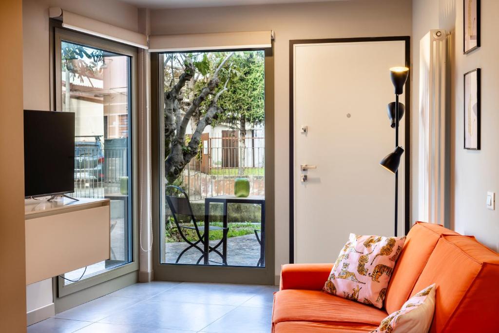 a living room with an orange couch and a sliding glass door at Stadler Loft in Marghera
