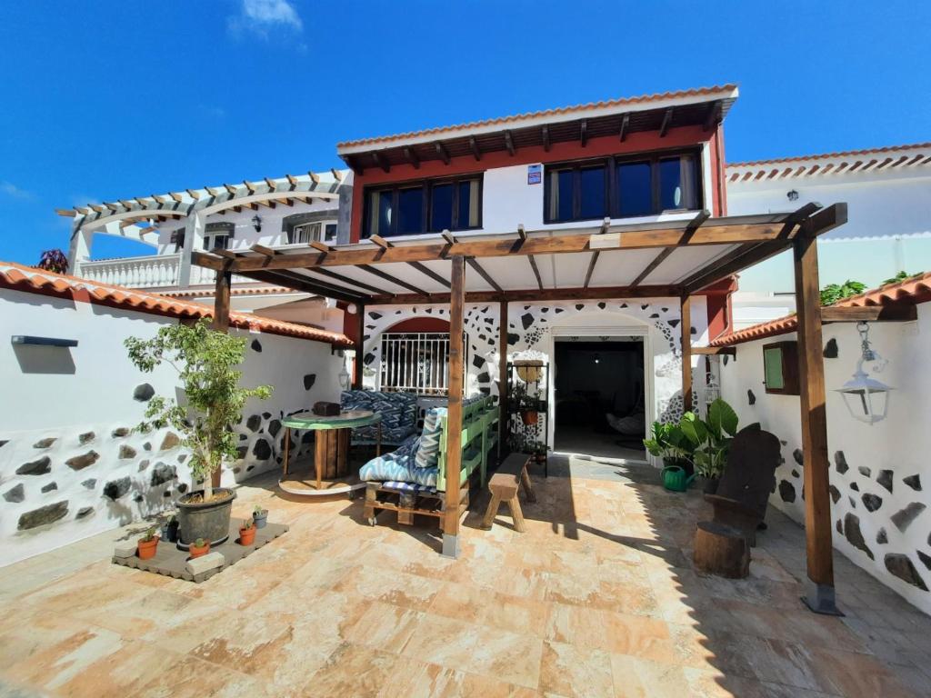 a house with a pergola in the yard at Oasis El Palmeral de Agaete in Agaete