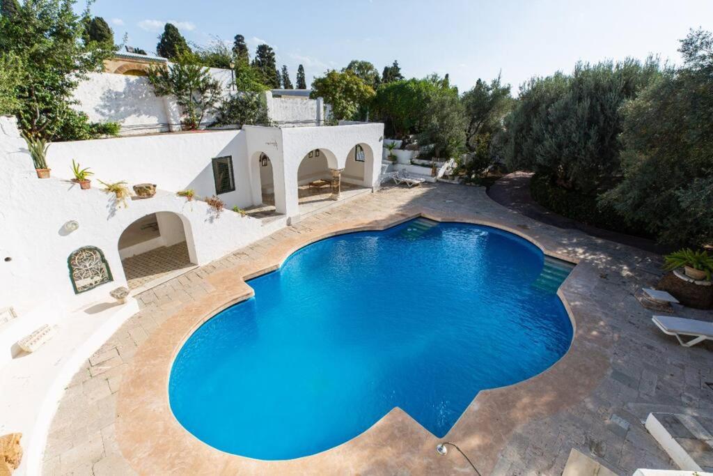 an image of a swimming pool in front of a house at Lella Kmar B&B avec piscine Sidi Bou Said in Sidi Bou Saïd