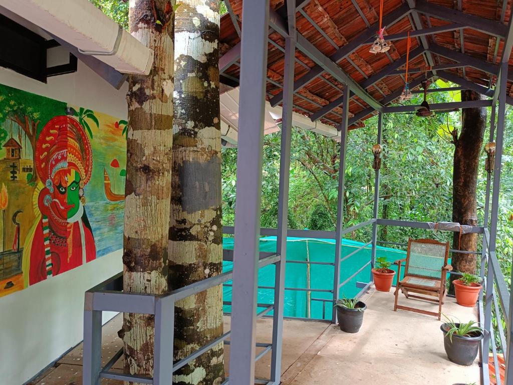 a room with a tree and a painting on the wall at Anandam Woods - A Heritage single Room for couple-small family in Vaikom