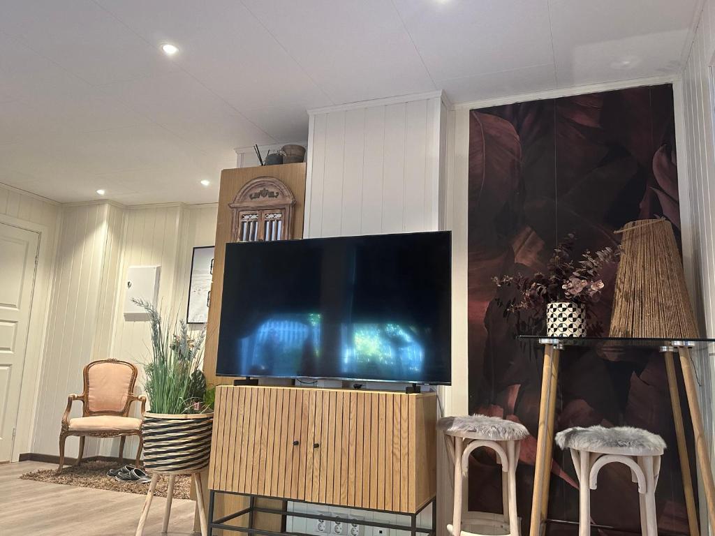 a flat screen tv sitting on a stand in a living room at Downtown Historical House with Renovated apartments in Ålesund