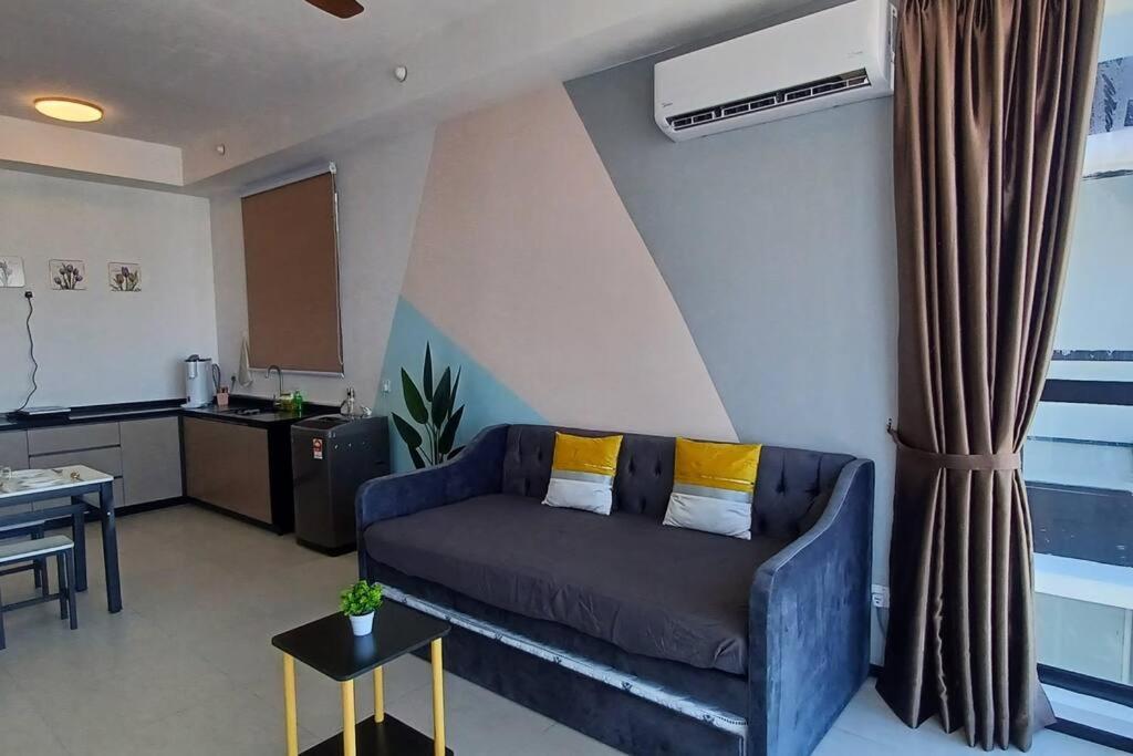 una sala de estar con un sofá y una mesa en Stylish Urban Suite Penang - with infinite pool, en Jelutong