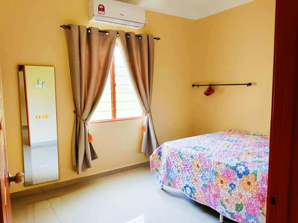 um quarto com uma cama e uma janela em Hanani Homestay em Shah Alam