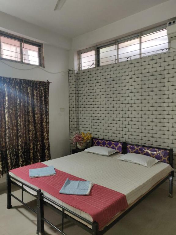 um quarto com uma cama e uma parede de tijolos em Crabs Homestay & Pg em Guwahati