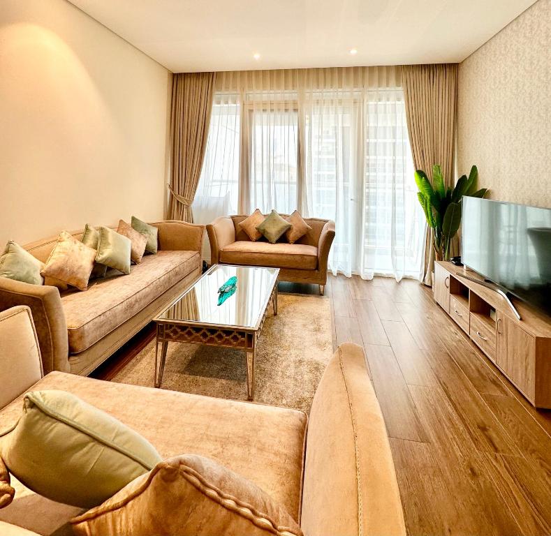 sala de estar con 2 sofás y TV de pantalla plana en Luxury Apartment with Part Lake View, en Sharjah