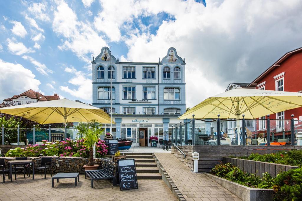 ein großes Gebäude mit gelben Sonnenschirmen davor in der Unterkunft Hotel Germania in Bansin