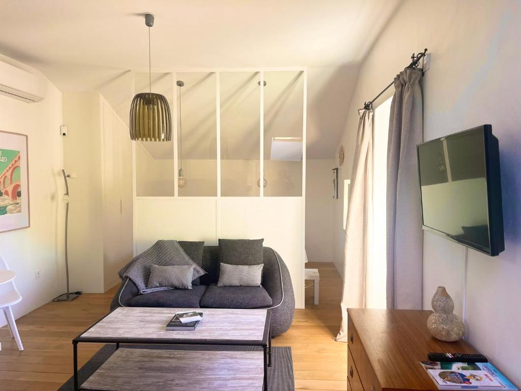 ein Wohnzimmer mit einem Sofa und einem Tisch in der Unterkunft Les Cerises du Pont du Gard in Remoulins