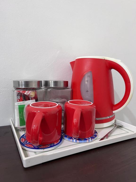 a tray with two red cups on a table at Studio Homestay in Sungai Buluh
