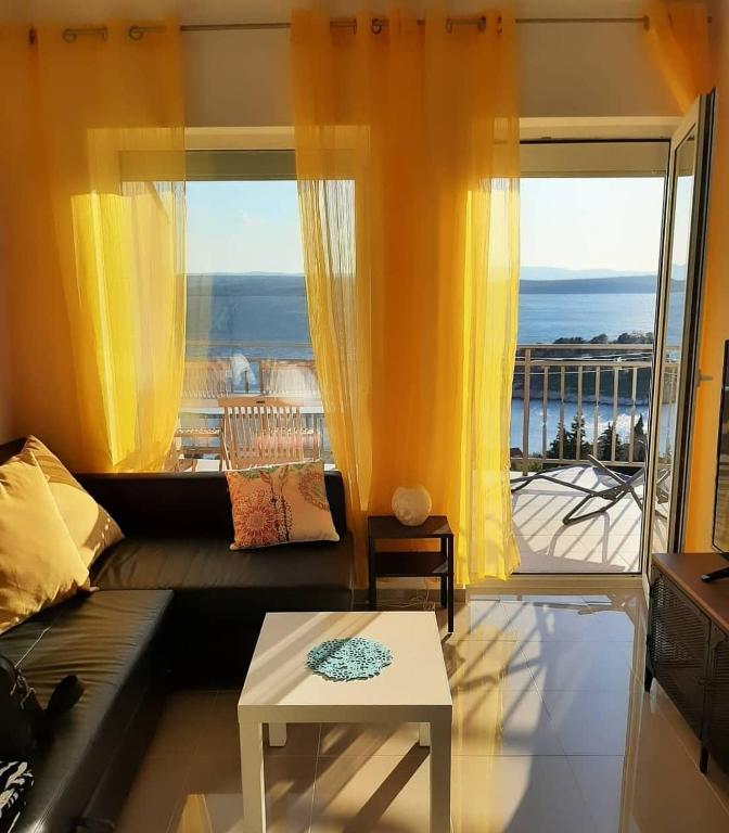 a living room with a couch and a large window at Apartman Rene, 150m from the sea, panorama view, Crikvenica, Dramalj, parking in Dramalj