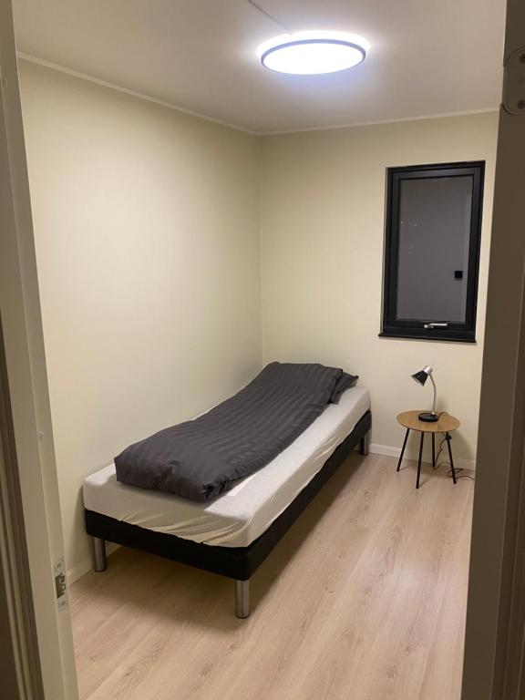um quarto com uma cama e uma mesa com um candeeiro em Rom # 3 Appartmenthotel Oslo Adress Isabels vei 16 em Oslo